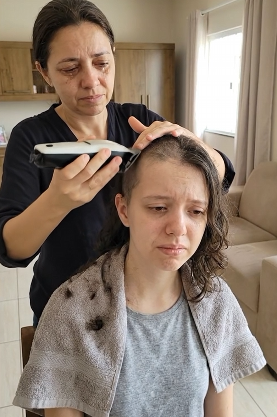 Mãe de Marcela raspando o cabelo dela em casa, ambas emocionadas durante o tratamento